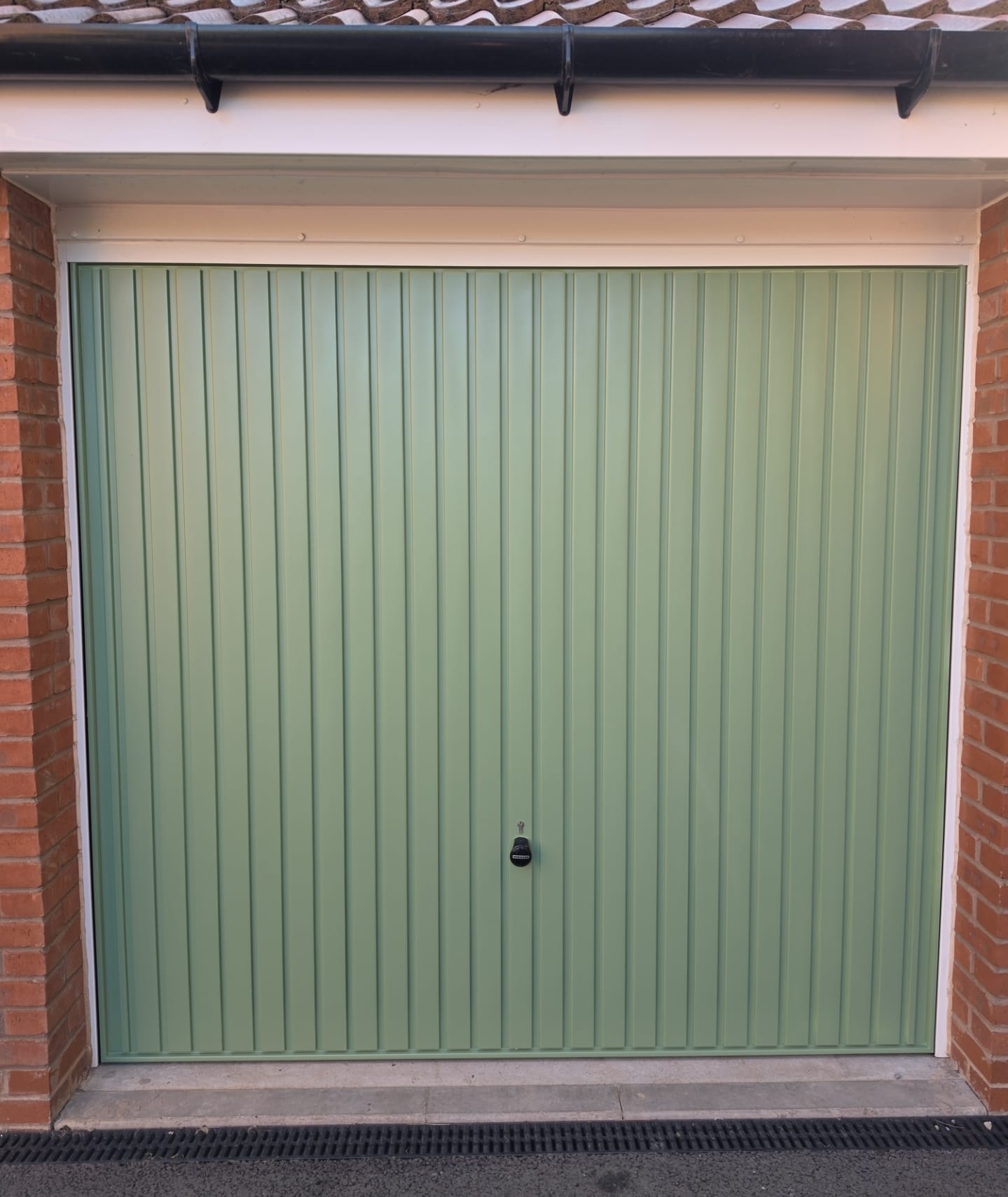 After: sage green up-and-over garage door