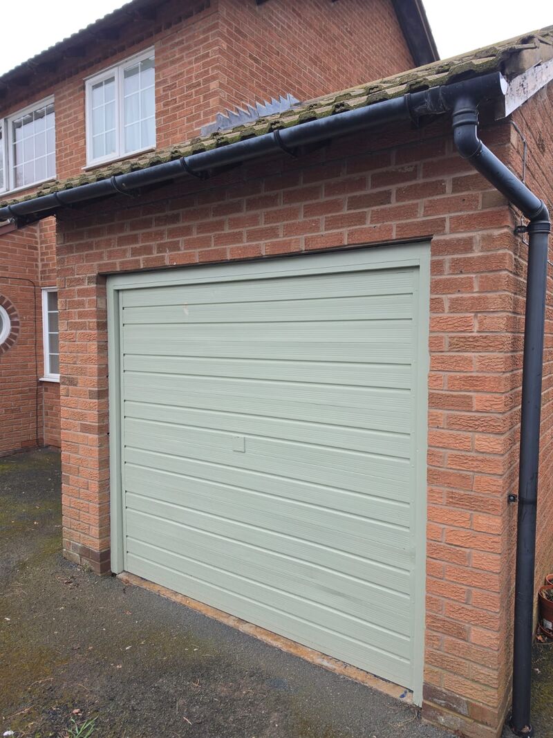 Before: faded green garage door